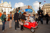 Mini ice cream van serving lollies and ice cream to customers.